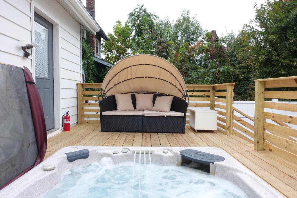 a jacuzzi tub on a deck next to a house at Best EWR Airport Apt-Hot Tub-Free Parking in Hillside