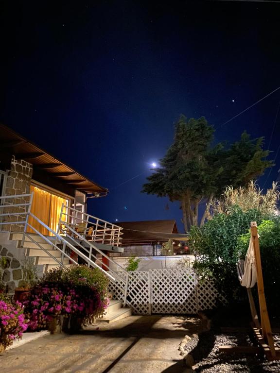 una casa con una escalera blanca y un árbol por la noche en Habitaciones Mar Azul, en El Quisco