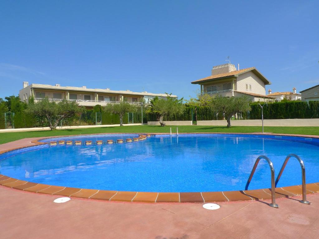 a large pool with blue water in front of a building at Holiday Home Mestral by Interhome in L'Ampolla