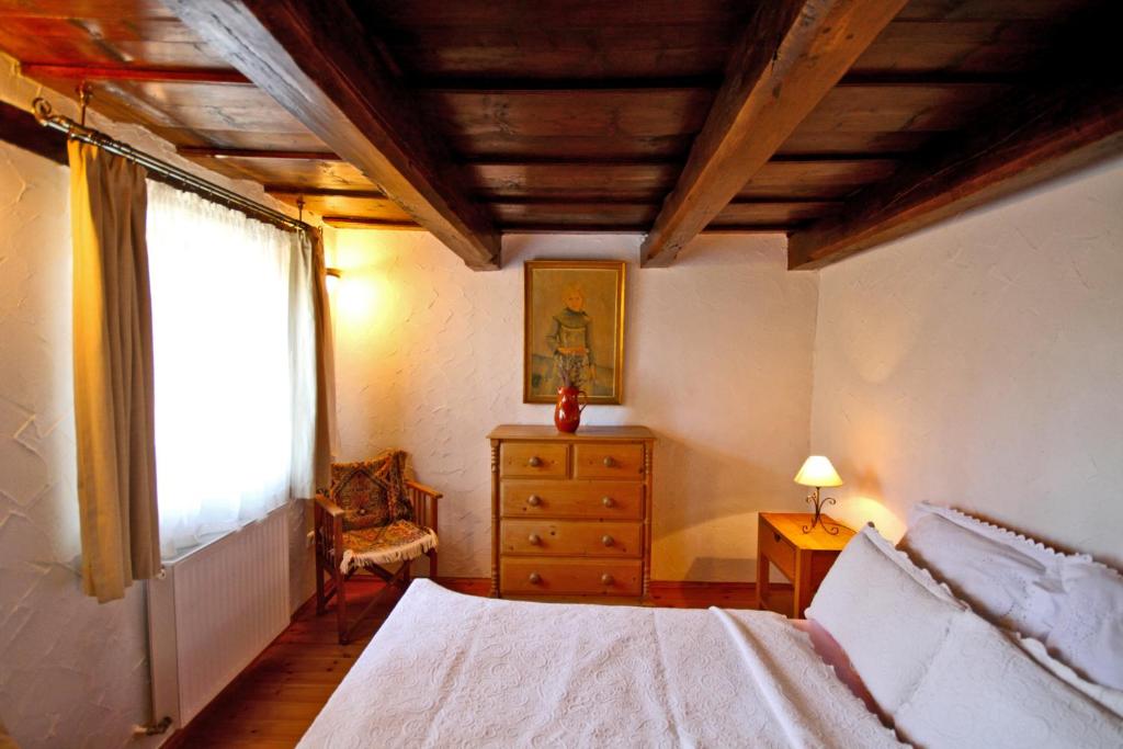 Sweet Cottage Vendégház في جينيسدياس: غرفة نوم بسرير وخزانة ونافذة