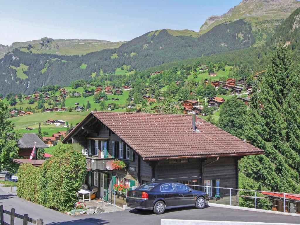 un coche aparcado frente a una casa con una montaña en Apartment Chalet Anna by Interhome, en Grindelwald