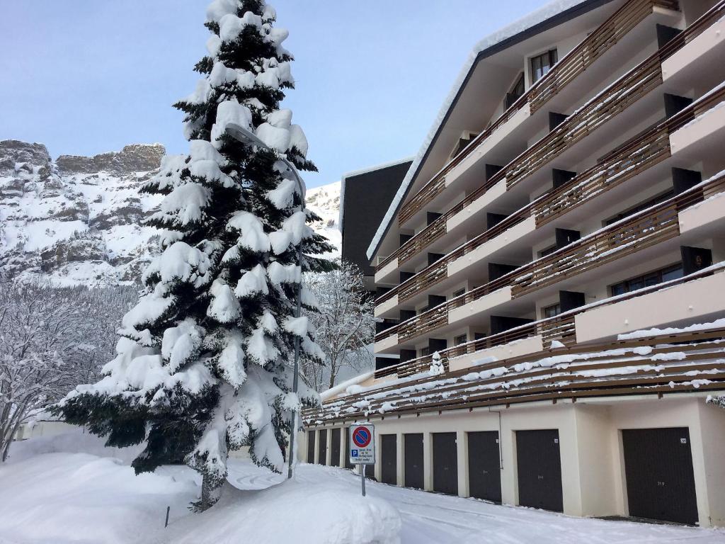 a snow covered christmas tree in front of a building at Apartment Ringstrasse - Utoring-38 by Interhome in Leukerbad