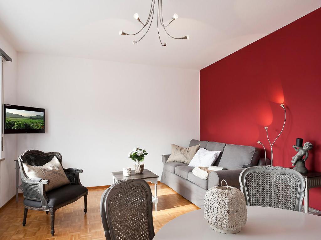 ein Wohnzimmer mit einem Sofa und einer roten Wand in der Unterkunft Apartment Michèle - Utoring-11 by Interhome in Ascona