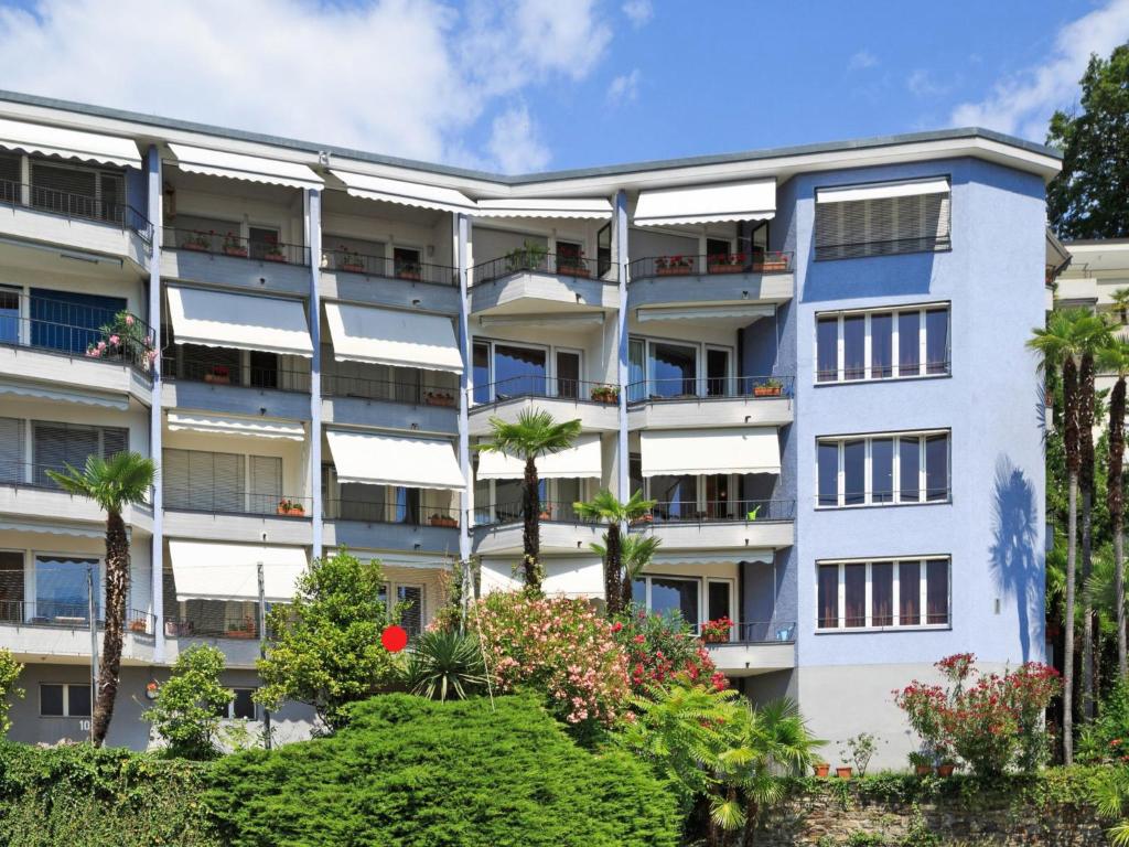 an apartment building with palm trees and bushes at Apartment Double Room Classic-8 by Interhome in Ascona