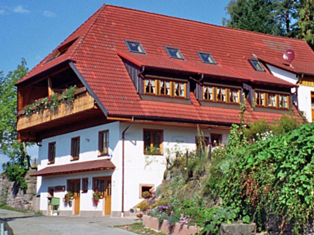 ein großes weißes Haus mit rotem Dach in der Unterkunft Apartment Biohof Herrenweg-2 by Interhome in Dreimühlen