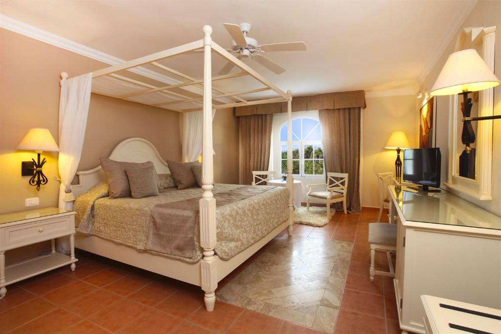 1 dormitorio con cama con dosel y TV en Bahia Principe Grand Samana - Adults Only en Santa Bárbara de Samaná