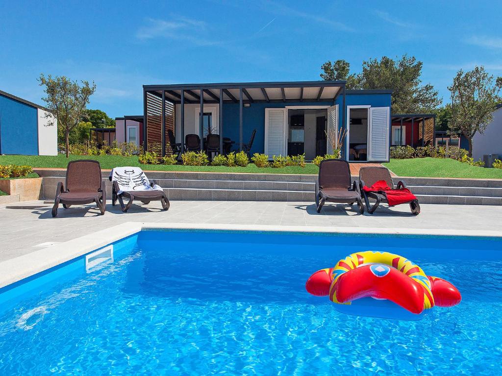 a swimming pool with a raft in the middle of it at Holiday Home Camping Kastanija-1 by Interhome in Novigrad Istria