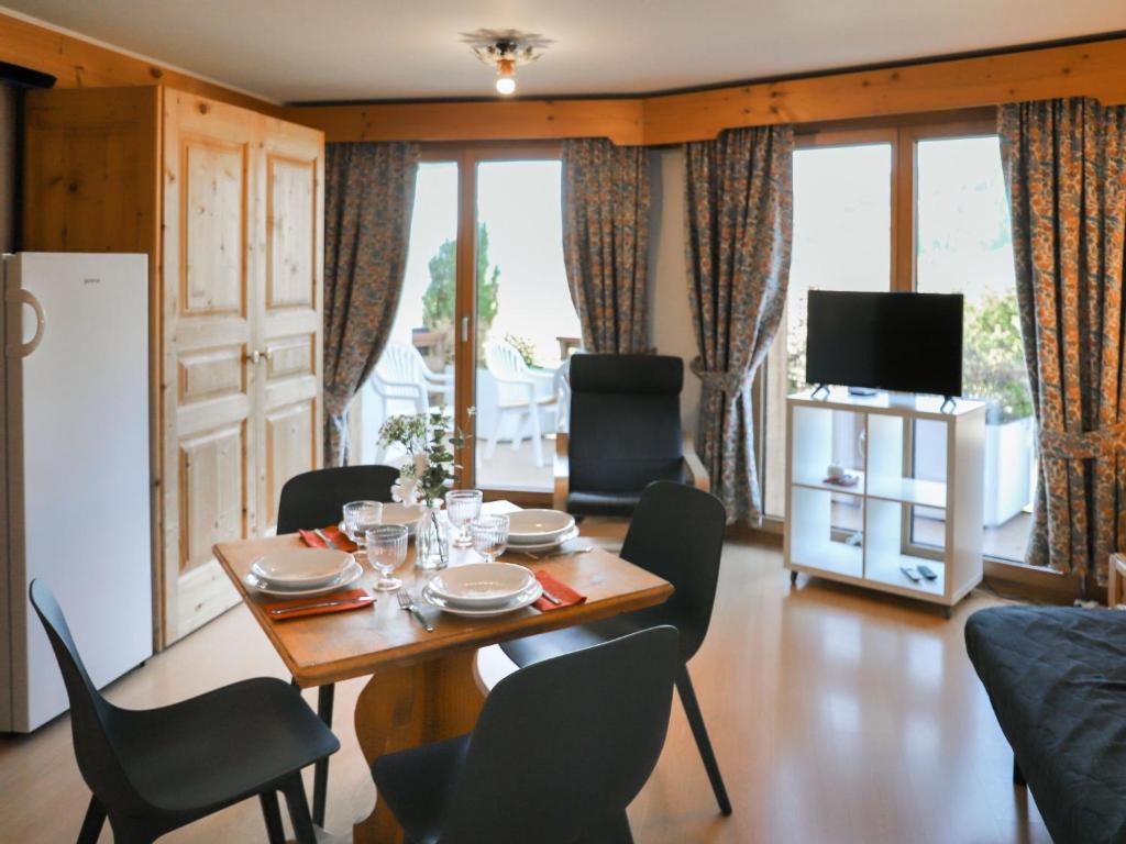 a dining room with a table and chairs and a television at Apartment Le Bristol A16 by Interhome in Villars-sur-Ollon