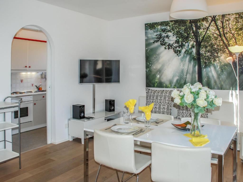 a kitchen and dining room with a white table and chairs at Apartment Residenza Corallo-16 by Interhome in Ascona