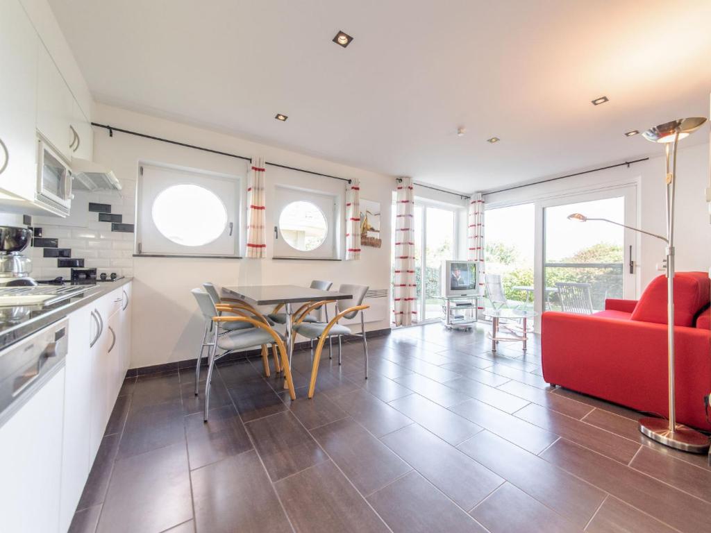 a kitchen and living room with a red couch and a table at Apartment Blutsyde Promenade-17 by Interhome in Mispelburg