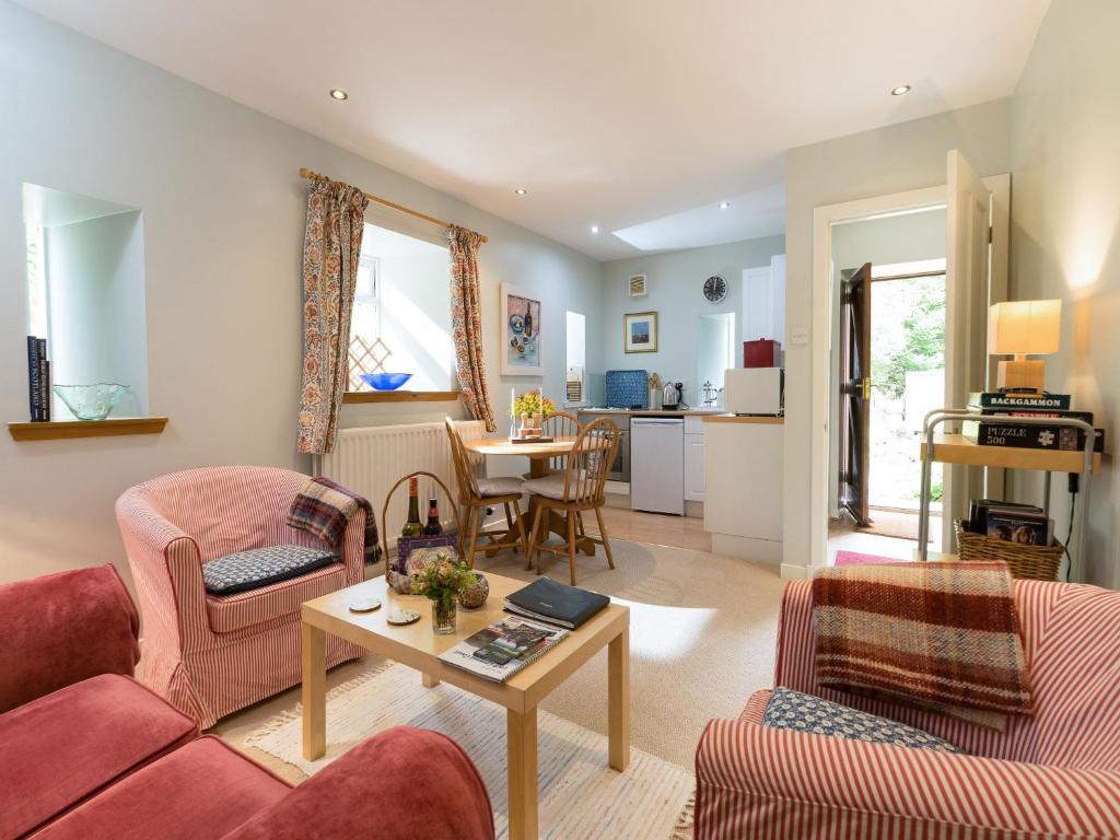 a living room with two couches and a table at Holiday Home Lorn Mill-2 by Interhome in Balloch
