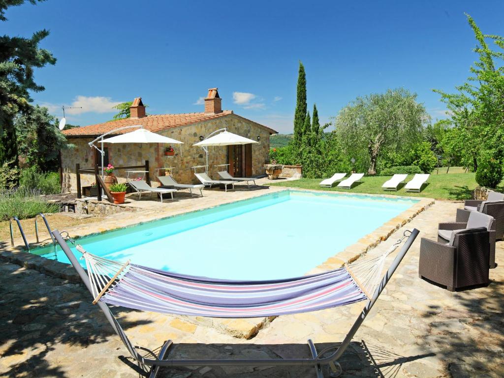 a pool with a hammock in front of a house at Holiday Home Casale Verciano by Interhome in Parrano