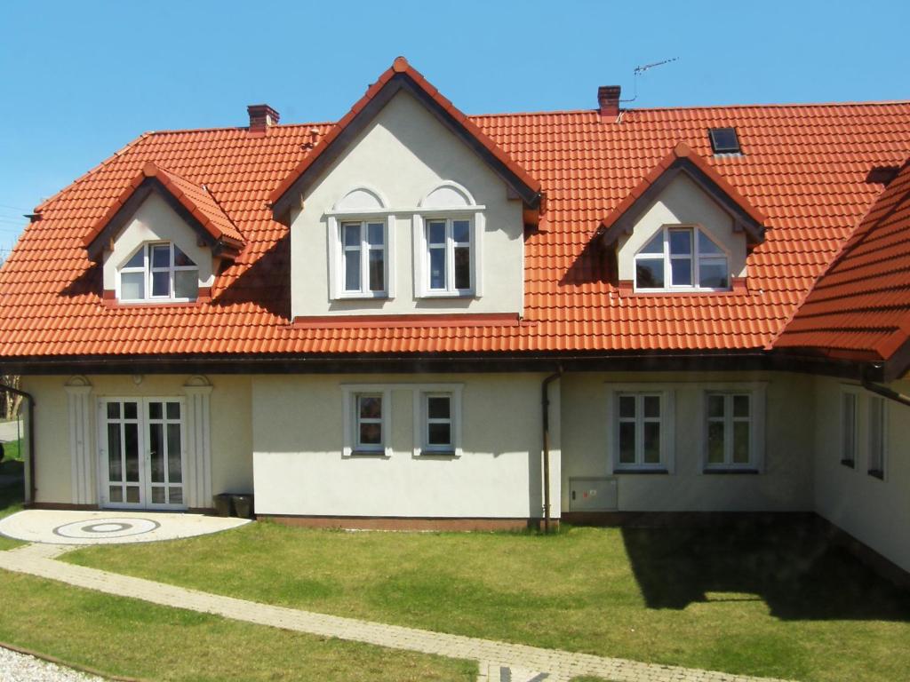 a house with an orange roof at Holiday Home Domek Joanna-1 by Interhome in Łeba