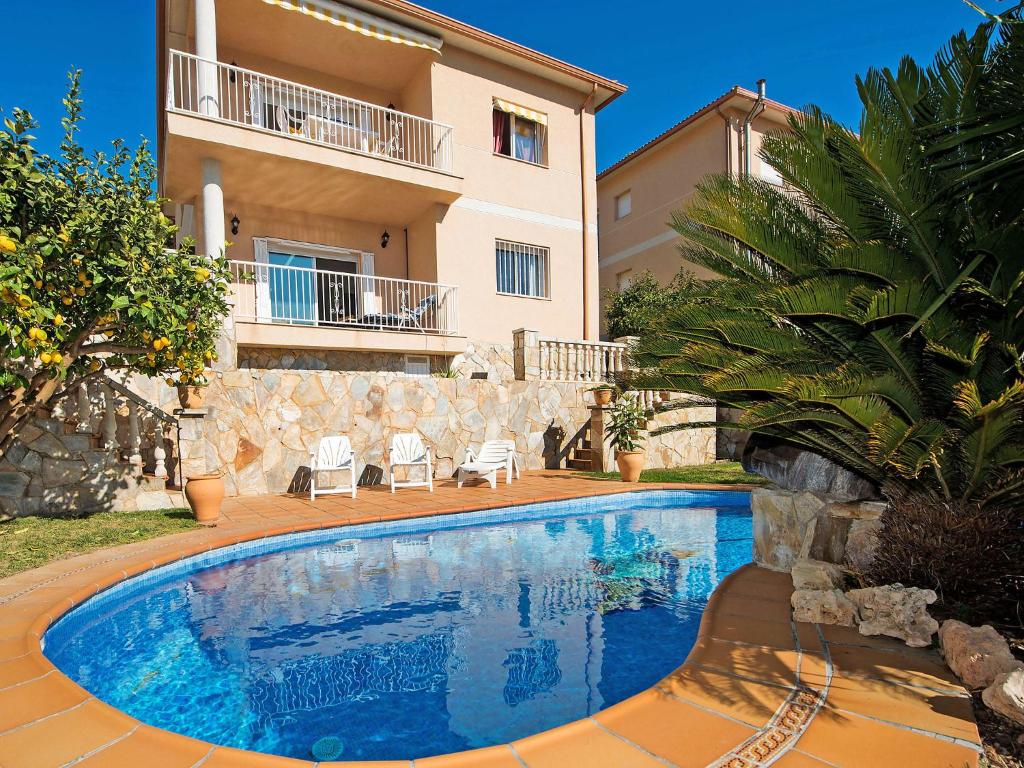 a villa with a swimming pool in front of a building at Holiday Home Juan by Interhome in Segur de Calafell