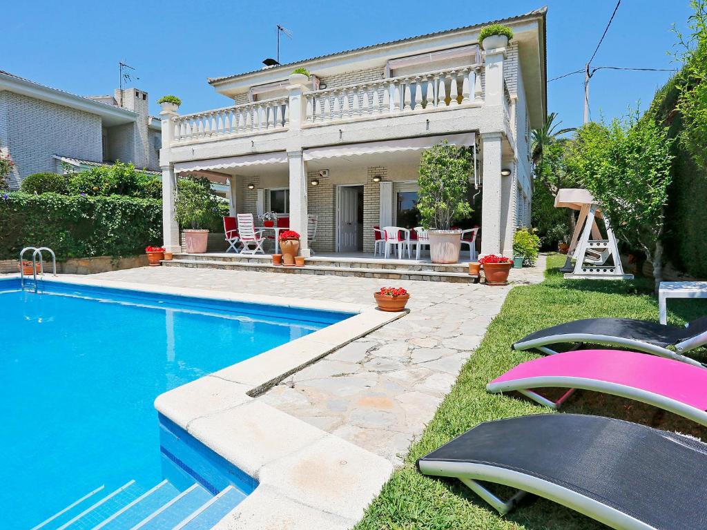 una casa con piscina y sillas en el patio en Holiday Home Annamaria by Interhome, en Vilafortuny