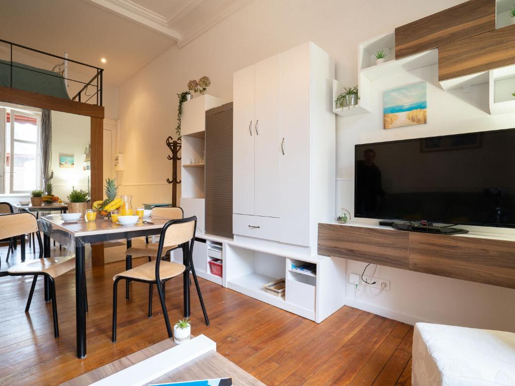 a living room with a dining table and a tv at Apartment Carlton-1 by Interhome in Biarritz