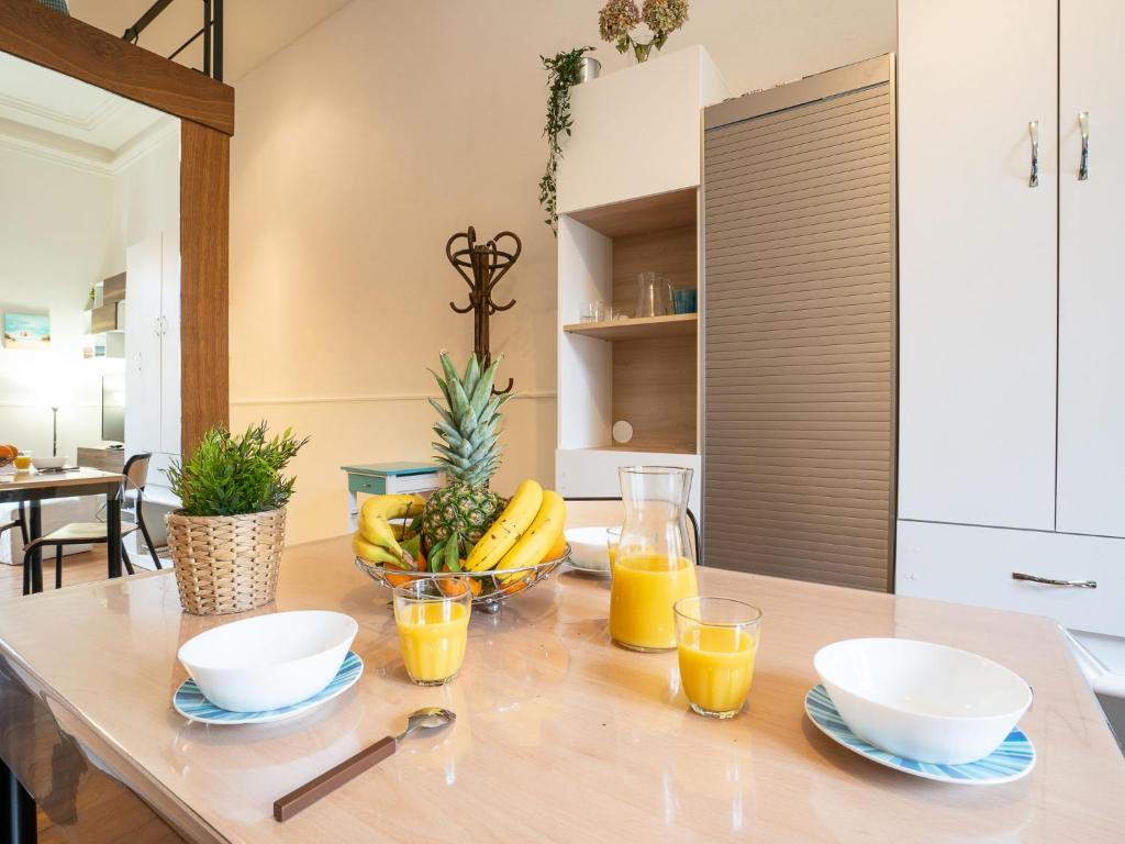 a table with bowls of fruit and glasses of orange juice at Apartment Carlton-1 by Interhome in Biarritz