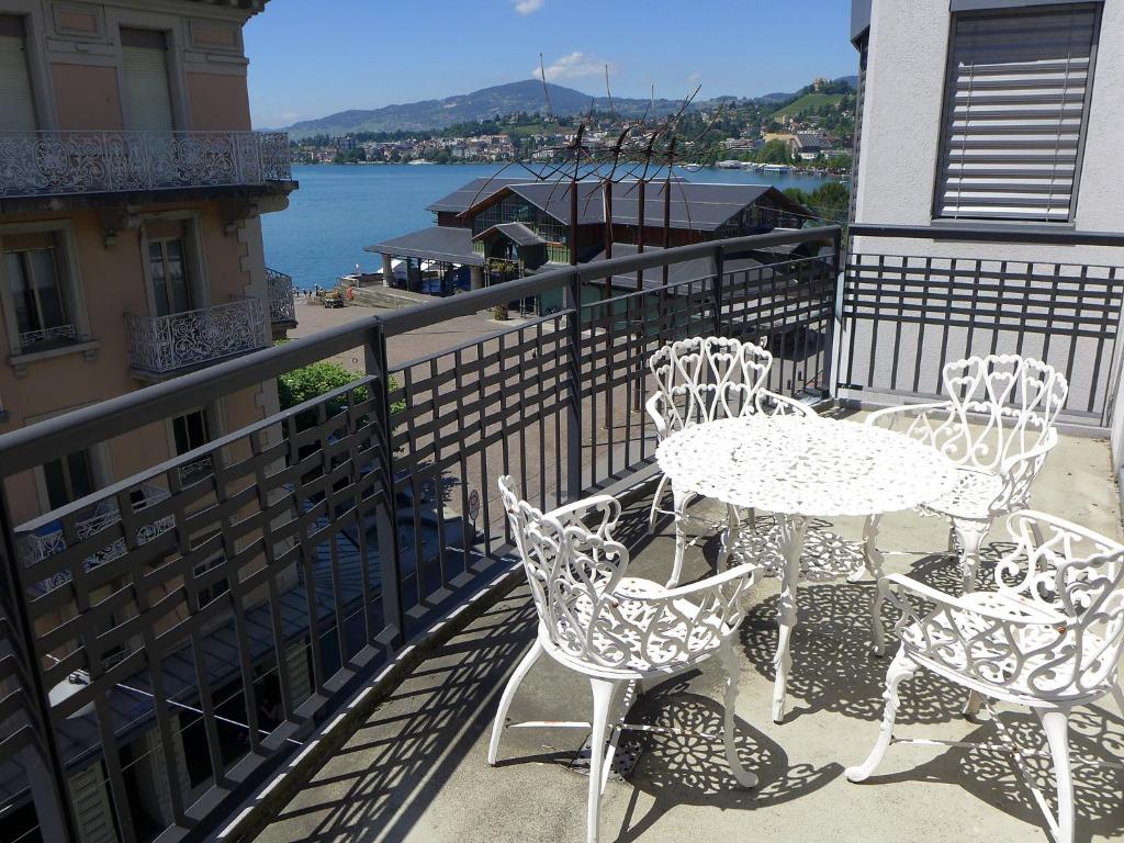 einen Tisch und Stühle auf einem Balkon mit Blick auf das Wasser in der Unterkunft Apartment Haute-Rive by Interhome in Montreux