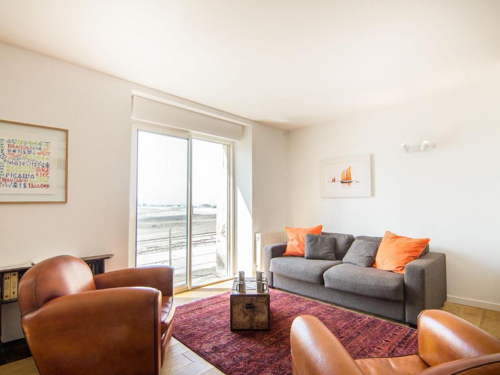 un salon avec un canapé, des chaises et une fenêtre dans l'établissement Apartment Dauphine by Interhome, à Saint-Malo