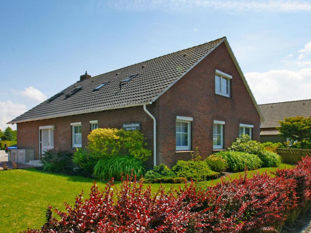 une maison en briques rouges avec un jardin en face de celle-ci dans l'établissement Apartment Juist by Interhome, à Norddeich