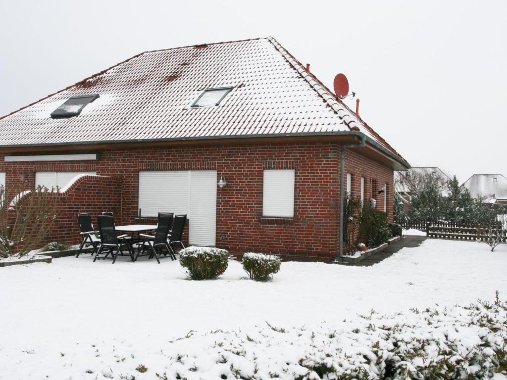 a house with a table and chairs in the snow at Holiday Home Martina by Interhome in Norddeich