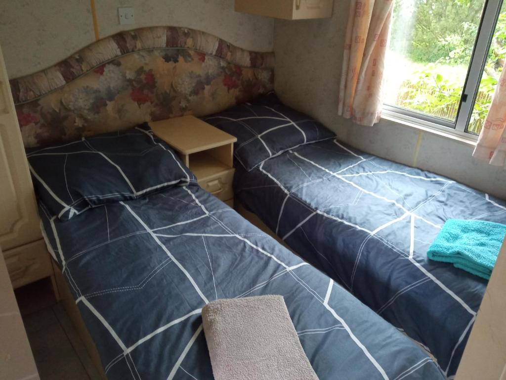 niewielka sypialnia z 2 łóżkami i oknem w obiekcie Domki Gucio i Maja w mieście Grodzisk Mazowiecki