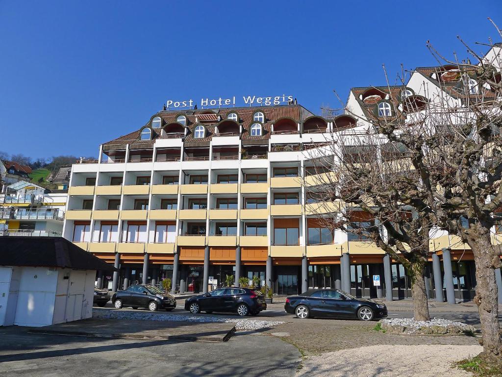 un gran edificio con coches estacionados frente a él en Apartment Seeblick by Interhome en Weggis