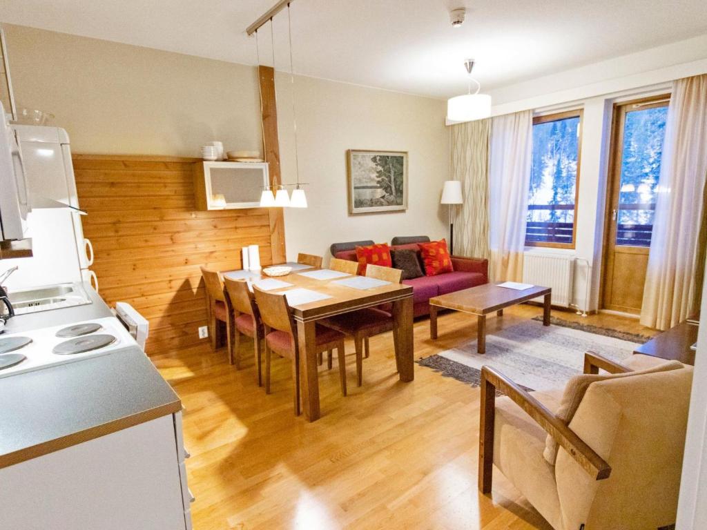 Una cocina y una sala de estar con una mesa y un sofá. en Holiday Home Ylläs chalets a508 by Interhome, en Ylläs