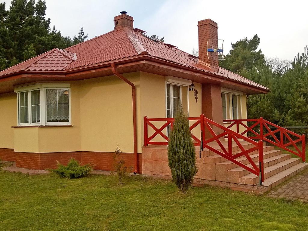 a small yellow house with a red roof at Holiday Home Smołdziński Las by Interhome in Smołdziński Las