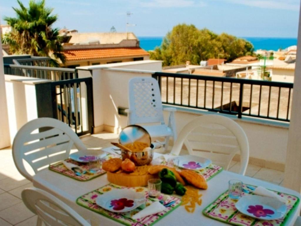 un tavolo su un balcone con vista sull'oceano di Apartment Cava Larica by Interhome a Cava dʼAliga