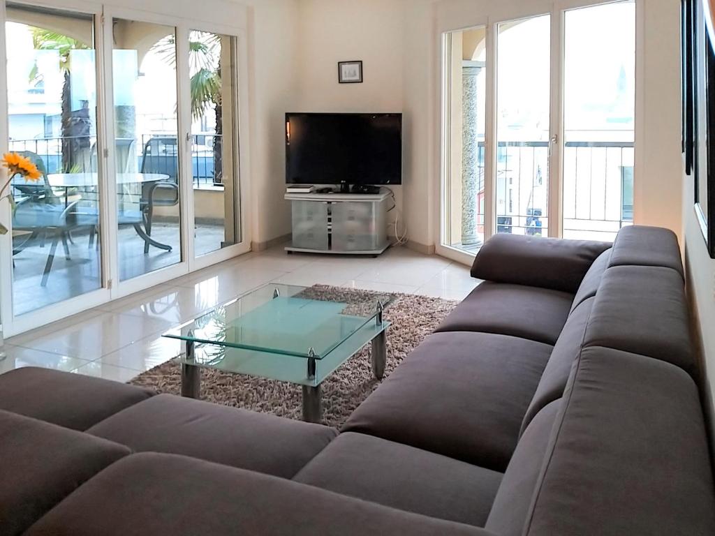 - un salon avec un canapé et une table basse en verre dans l'établissement Apartment Residenza Moro by Interhome, à Ascona