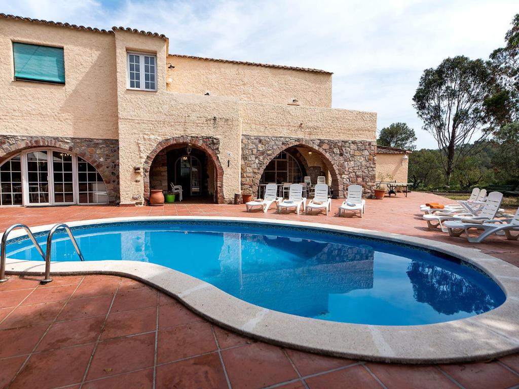 a swimming pool in front of a house at Holiday Home Can Trullas by Interhome in Viladecaballs