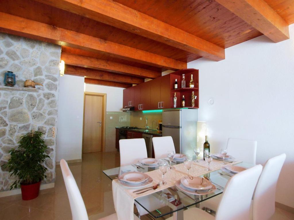 jadalnia ze szklanym stołem i białymi krzesłami w obiekcie Holiday Home Villa Sandra by Interhome w mieście Kruševo