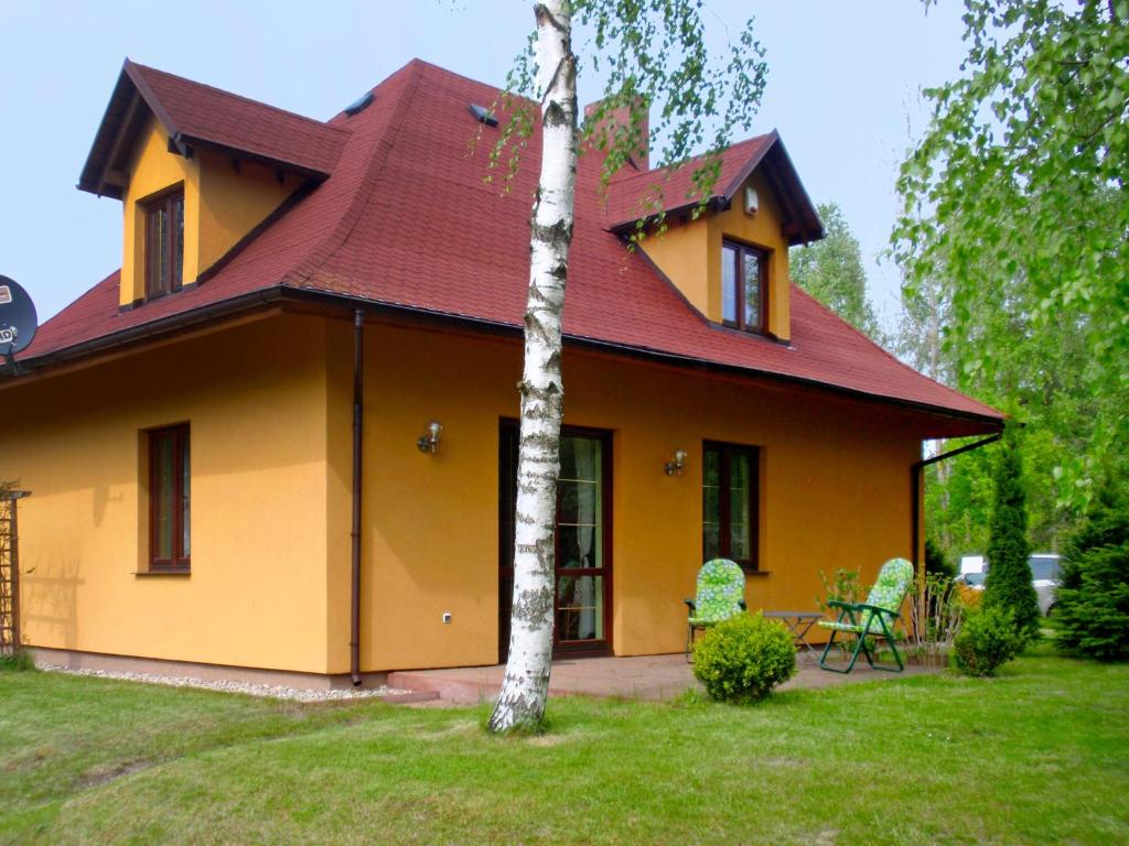a yellow house with a red roof at Holiday Home Borowikowa by Interhome in Sasino