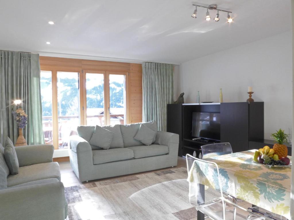 uma sala de estar com um sofá e uma mesa em Apartment Bella Vista-3 by Interhome em Wengen