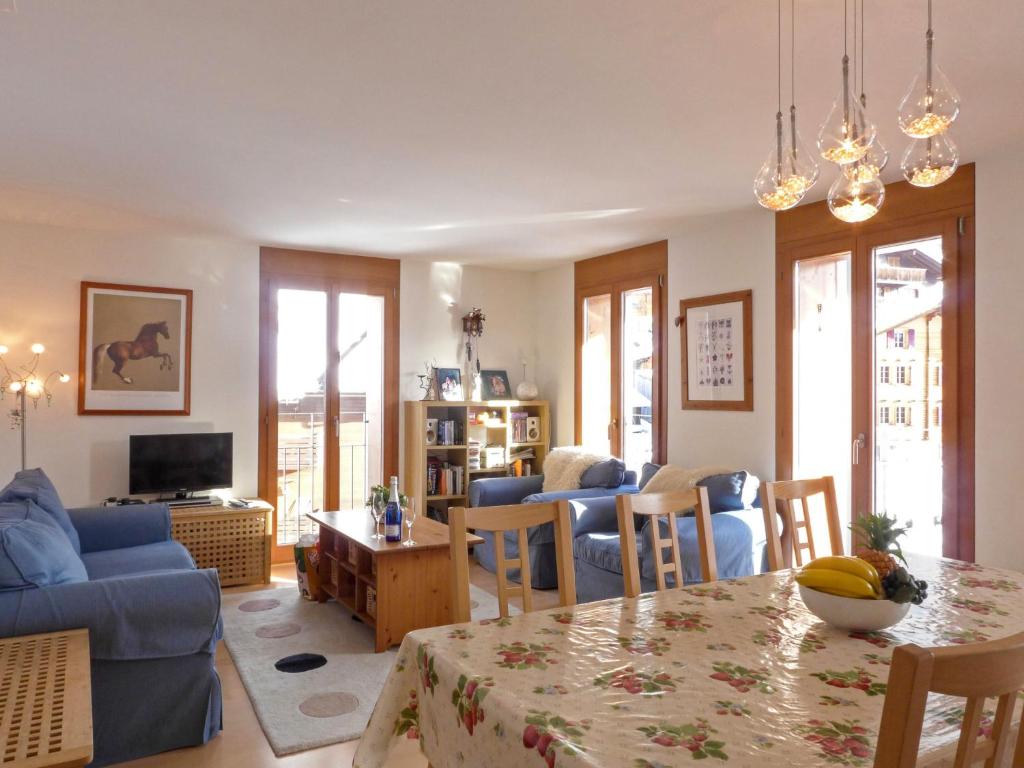 a living room with a blue couch and a table at Apartment Eden by Interhome in Wengen