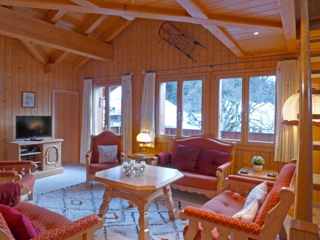 a living room filled with furniture and a table at Apartment Roossihuus by Interhome in Wengen