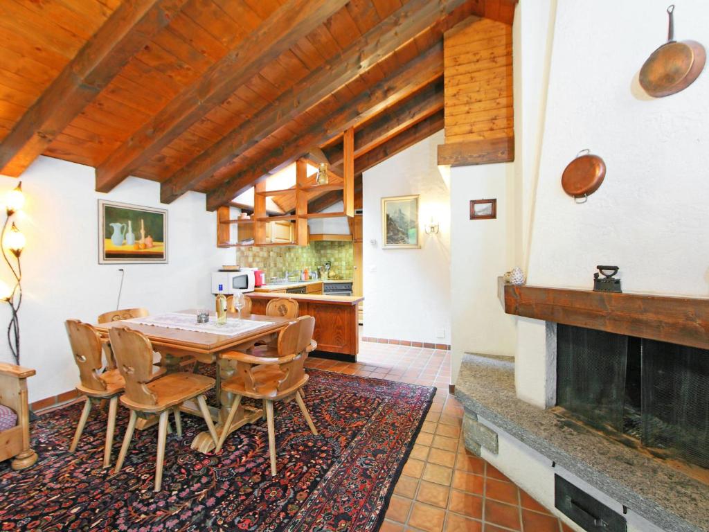 een eetkamer met een tafel en stoelen en een open haard bij Apartment Vitalis by Interhome in Zermatt