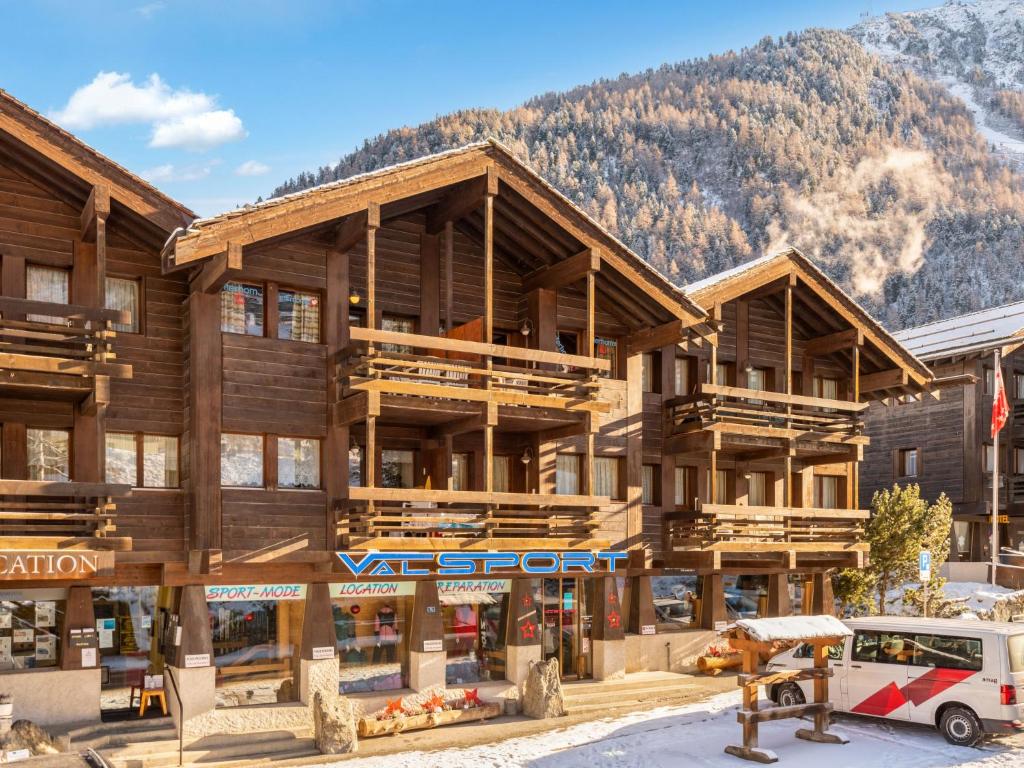 un gran edificio de madera con una montaña en el fondo en Apartment Tarcianne A Apt- 2 by Interhome, en Grimentz