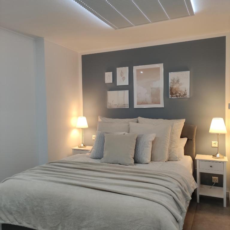 a bedroom with a large white bed with two lamps at Appartement Mond in Senftenberg