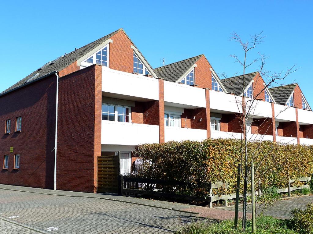 un edificio de ladrillo rojo con una calle delante de él en Apartment Borkum by Interhome, en Dornumersiel