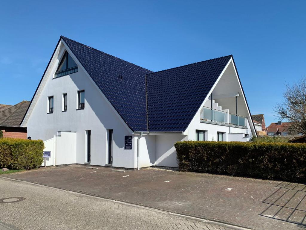 a white house with a black roof at Apartment Witthuus-Borkum by Interhome in Norddeich