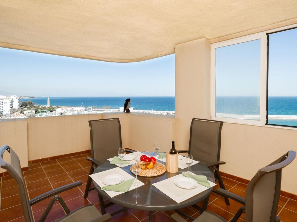 un comedor con mesa y sillas y el océano en Apartment Puerto Paraíso by Interhome, en Estepona