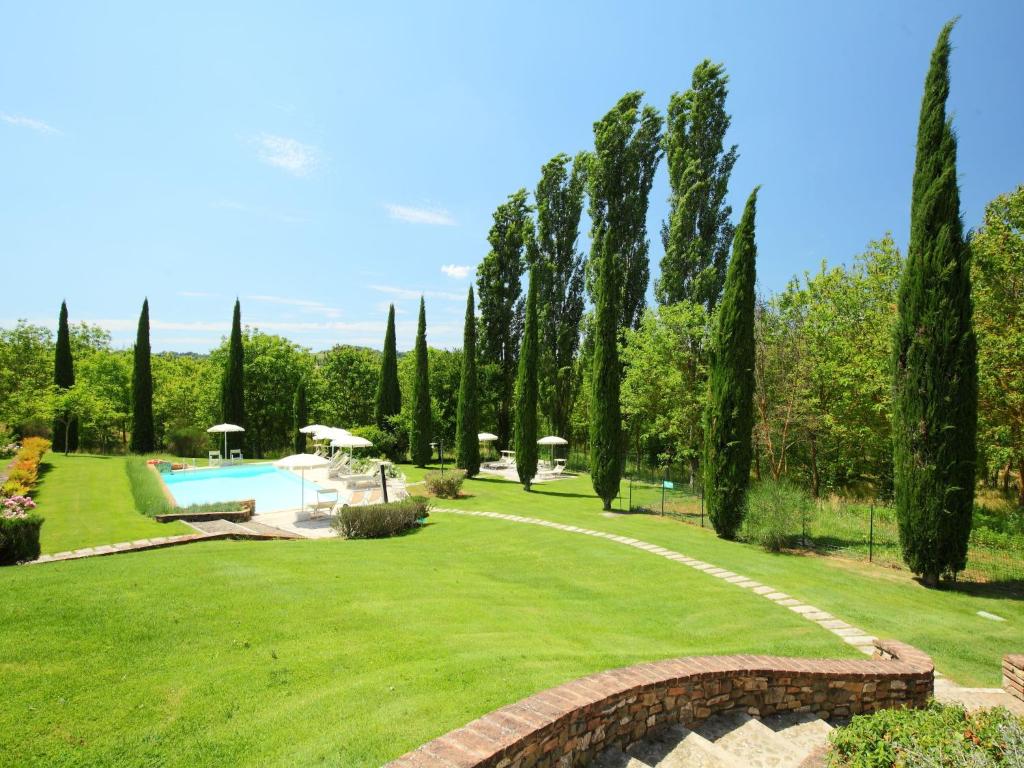 a garden with a swimming pool and trees at Apartment Rapolano-5 by Interhome in Rapolano Terme