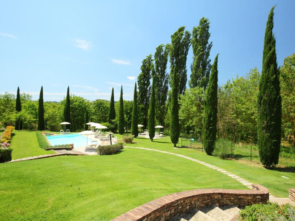 a garden with a swimming pool and trees at Apartment Forno by Interhome in Rapolano Terme