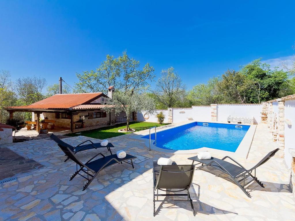 een terras met stoelen en een zwembad bij Apartment Majda by Interhome in Kmeti