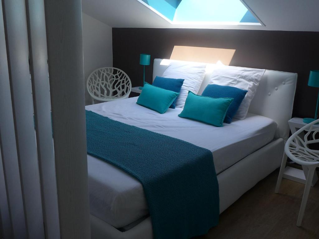 a bedroom with a white bed with blue pillows at Apartment Les Berges Landaises-1 by Interhome in Soorts-Hossegor