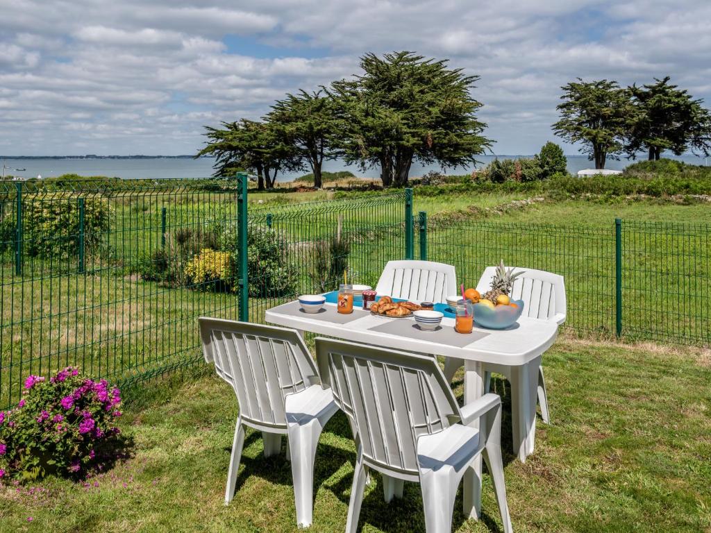 een witte tafel met stoelen en een fruitschaal bij Apartment Domaine de la Greve by Interhome in Saint-Pierre-Quiberon