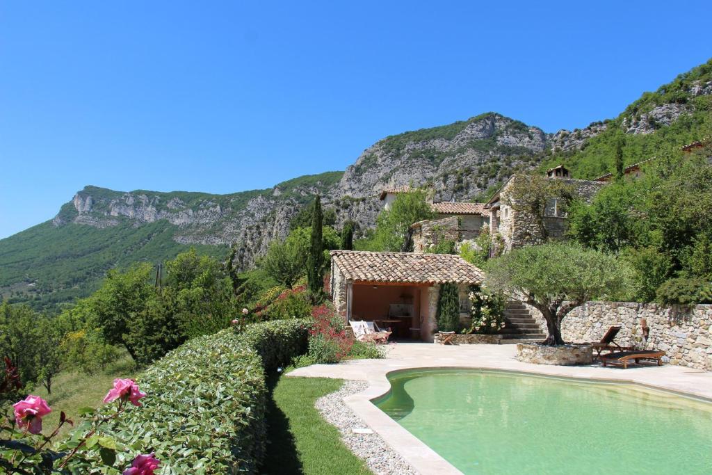 een huis en een zwembad met bergen op de achtergrond bij Domaine du Roc in Saou