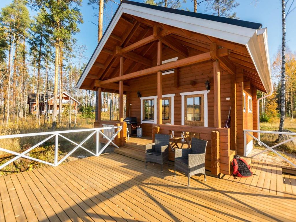 Cabaña de madera con mesa y sillas en una terraza en Holiday Home Joutsen by Interhome, en Vähäsalmi